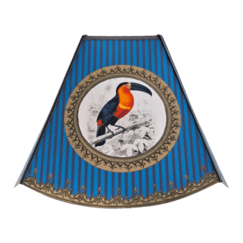 Decorative blue striped lamp shade with a circular gold-framed image of a bright orange and black toucan on a branch.
